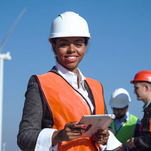 Female engineer at wind farm holding tablet